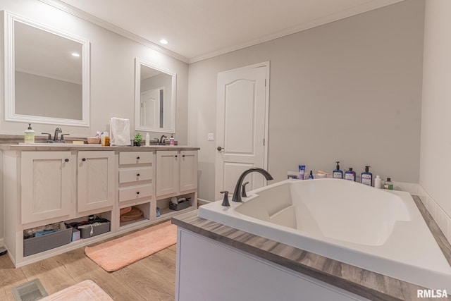 full bath with a sink, crown molding, double vanity, and wood finished floors