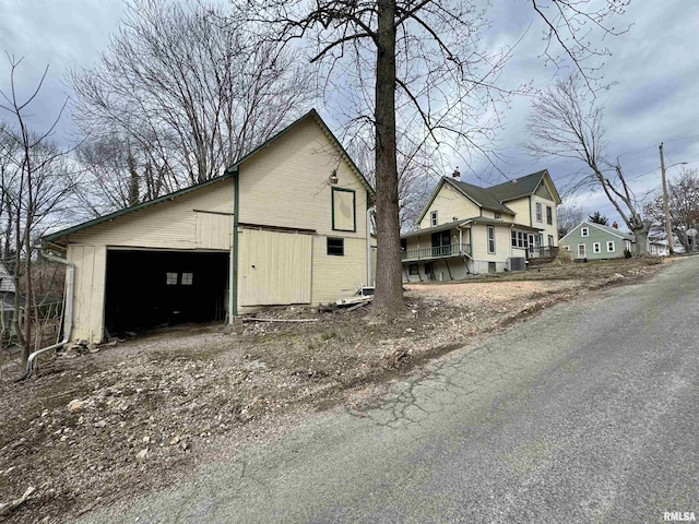 view of side of home with a garage and an outbuilding