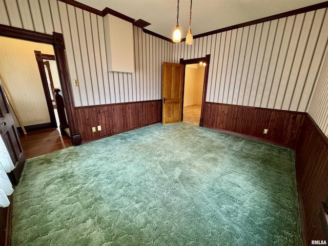 carpeted spare room featuring a wainscoted wall and wallpapered walls