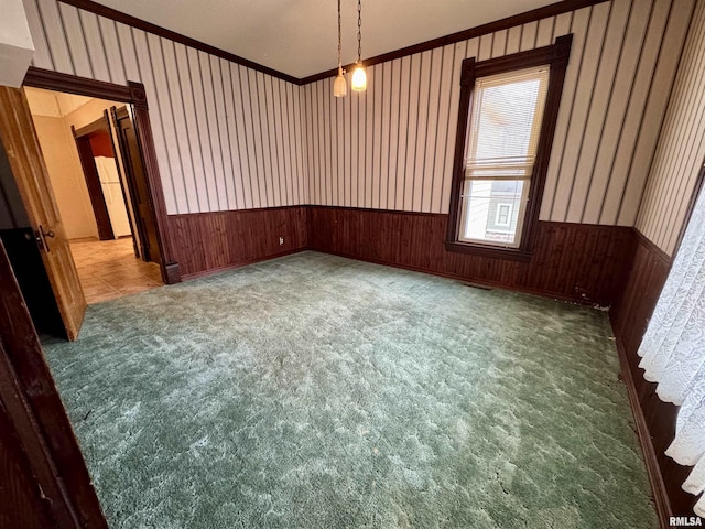 unfurnished room with carpet floors, wainscoting, and wallpapered walls