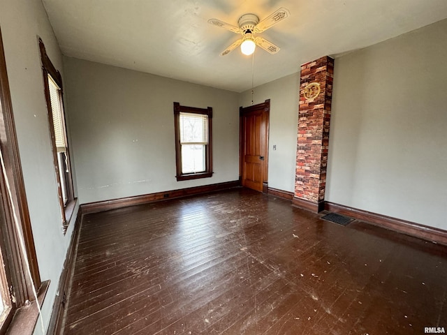 unfurnished room featuring a ceiling fan, baseboards, visible vents, and hardwood / wood-style floors