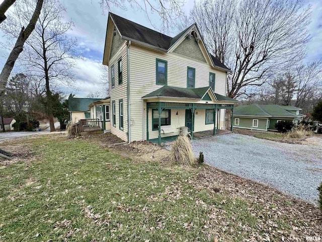 victorian house with driveway and a front lawn