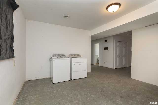 clothes washing area with laundry area, visible vents, and washer and dryer