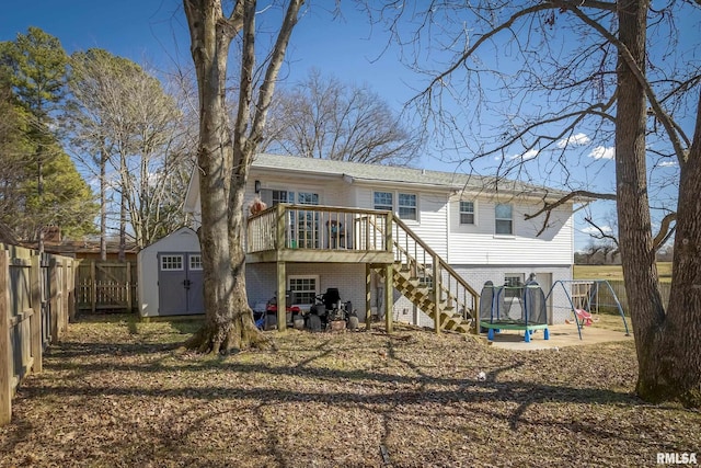 rear view of property featuring a fenced backyard, stairway, an outbuilding, a shed, and brick siding