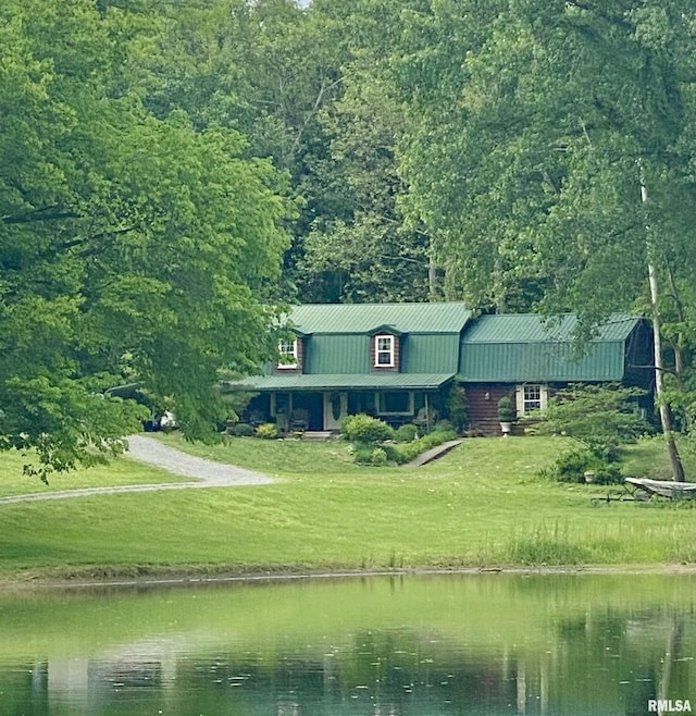 view of front of property with metal roof, a water view, a gambrel roof, a forest view, and a front yard