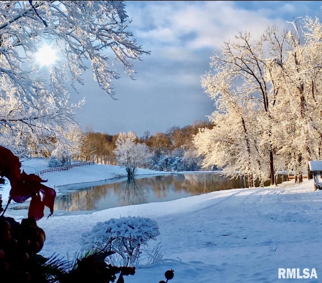 yard layered in snow featuring a water view