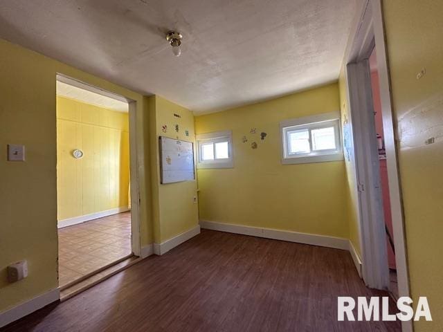 unfurnished room featuring baseboards and wood finished floors