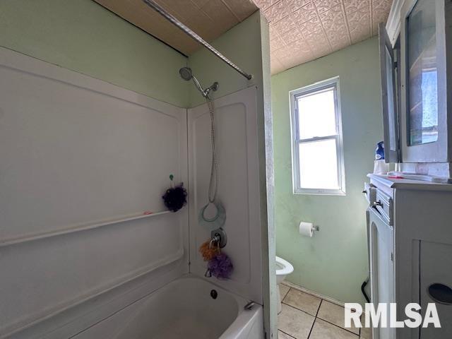 bathroom with toilet, shower / tub combination, tile patterned flooring, and vanity