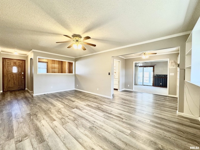 unfurnished living room with crown molding, ceiling fan, a textured ceiling, wood finished floors, and baseboards