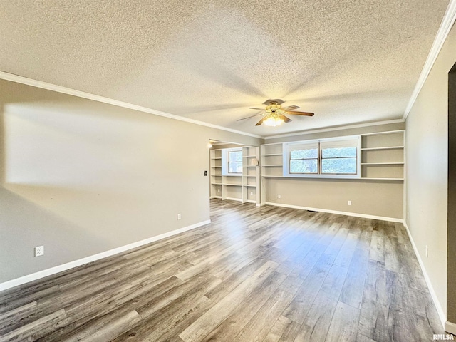 empty room featuring dark wood-style flooring, ornamental molding, ceiling fan, a textured ceiling, and baseboards