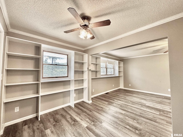 unfurnished room featuring a textured ceiling, wood finished floors, and crown molding