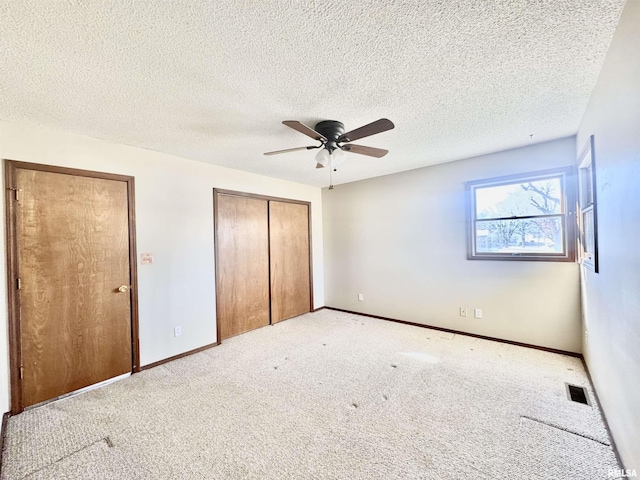 unfurnished bedroom featuring carpet floors, a closet, visible vents, a ceiling fan, and baseboards