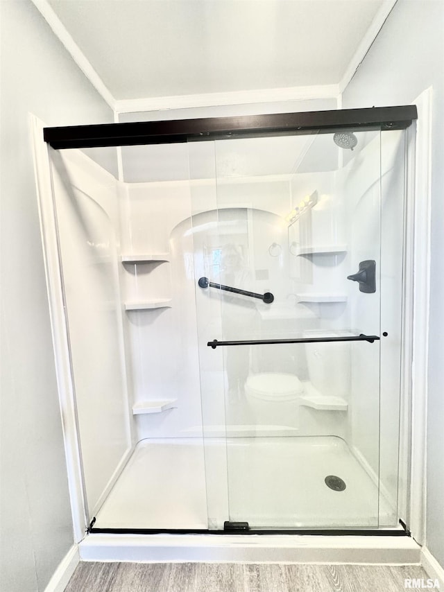 full bathroom featuring a stall shower, wood finished floors, and baseboards