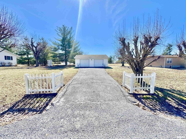 exterior space with a fenced front yard, a detached garage, an outdoor structure, and a front yard