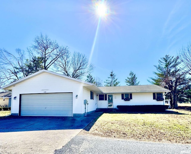 single story home with driveway, an attached garage, and a front yard