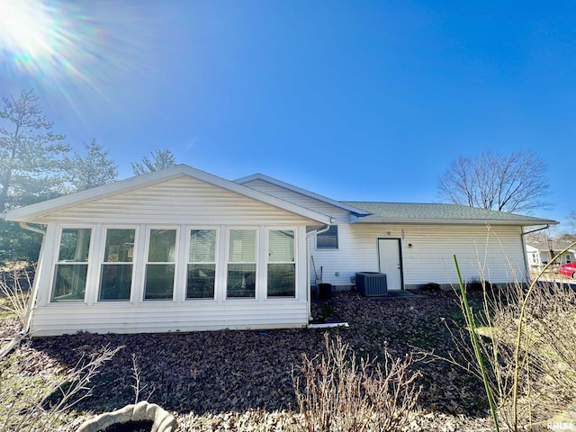 rear view of property with central AC and a sunroom