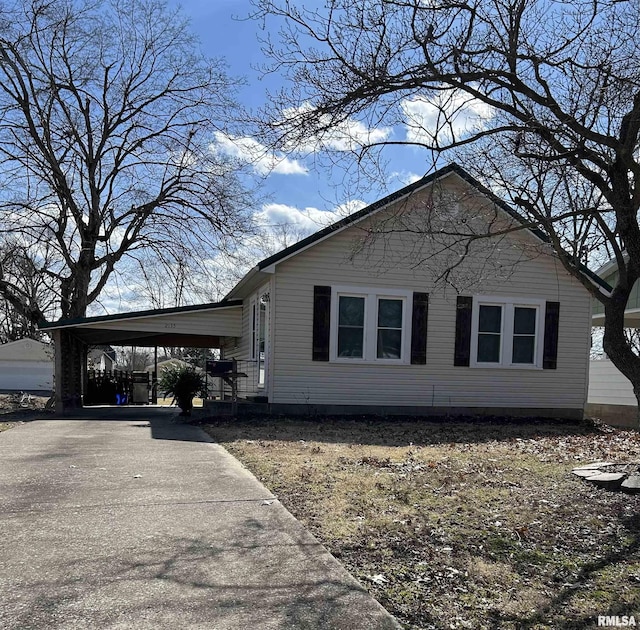 view of property exterior with a carport and concrete driveway