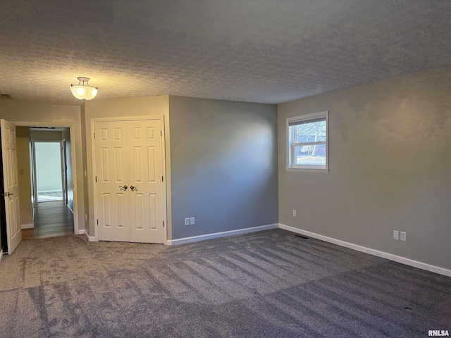 unfurnished room featuring carpet, visible vents, a textured ceiling, and baseboards