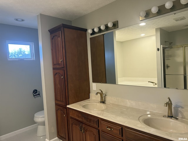 full bath with a textured ceiling, double vanity, a sink, and a shower stall