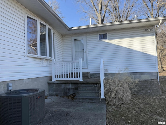 property entrance featuring crawl space and cooling unit