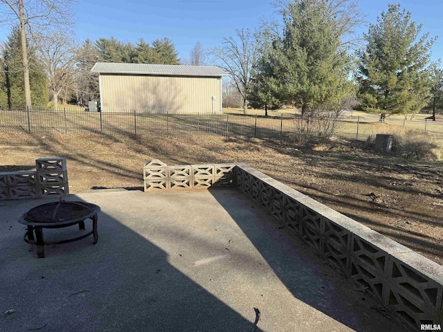 view of yard featuring an outbuilding, a pole building, fence, and a fire pit