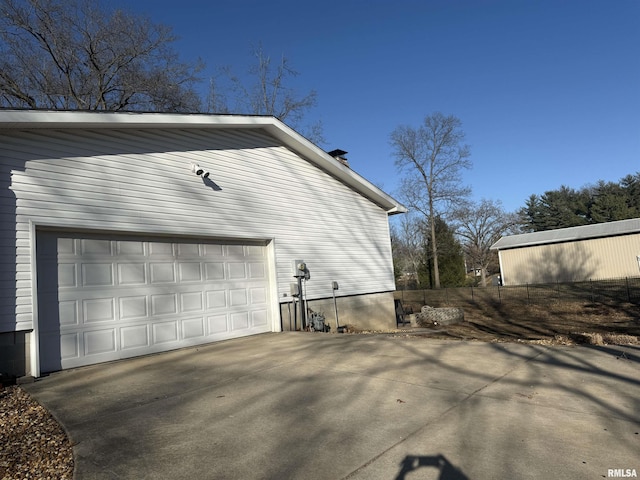 view of side of home with a garage and concrete driveway