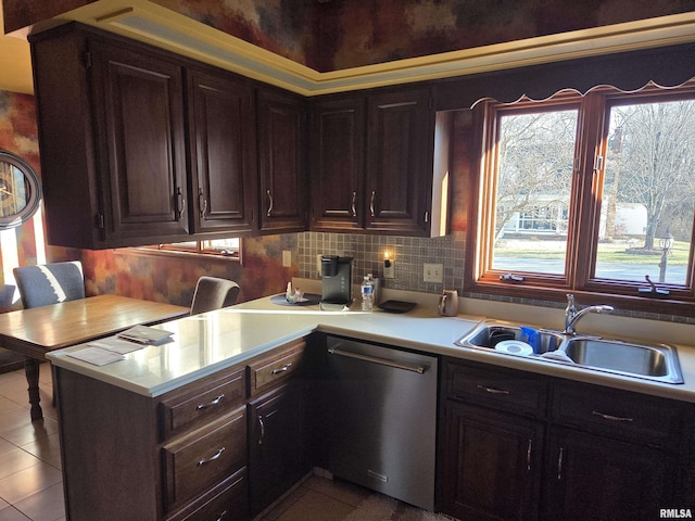 kitchen featuring light countertops, stainless steel dishwasher, light tile patterned flooring, and a sink