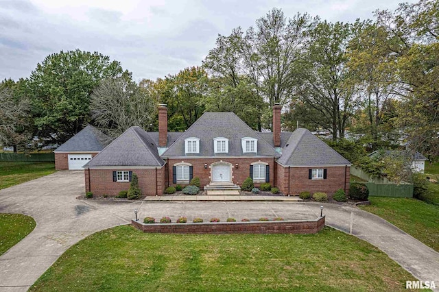 view of front of home with brick siding, fence, and a front lawn