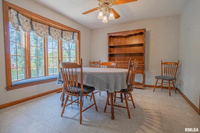 dining room with light tile patterned flooring, ceiling fan, and baseboards