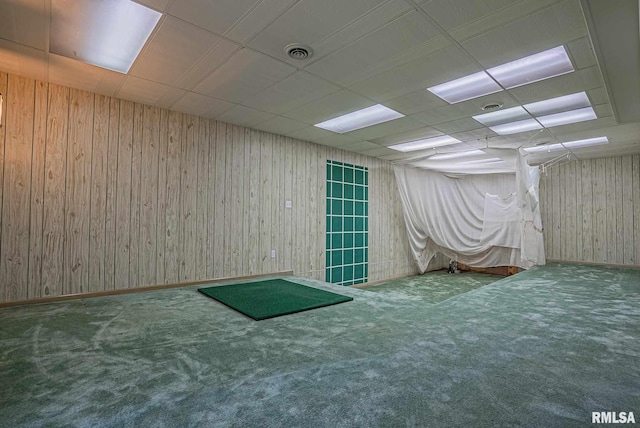 carpeted empty room featuring a paneled ceiling, visible vents, and baseboards