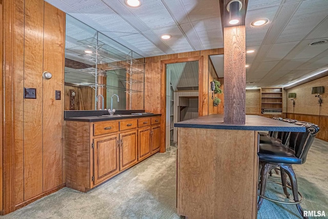 bar with light colored carpet, indoor wet bar, wood walls, a sink, and recessed lighting