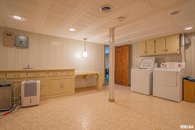 clothes washing area featuring washing machine and dryer, visible vents, cabinet space, and light floors