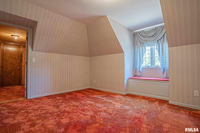 additional living space featuring carpet floors, wallpapered walls, and visible vents