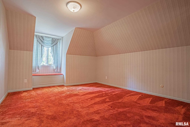 bonus room featuring lofted ceiling, wallpapered walls, baseboards, and carpet floors