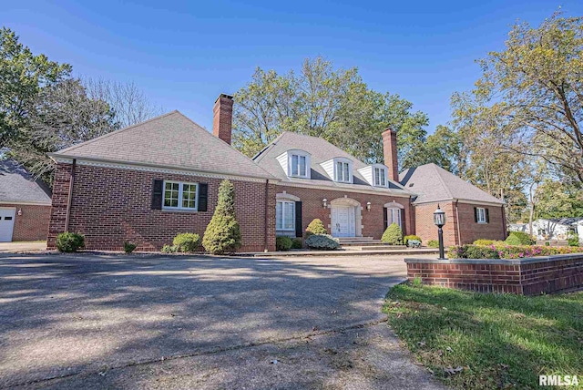 view of front of property with brick siding and a chimney