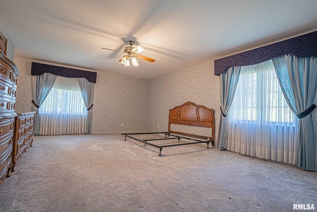 unfurnished bedroom with carpet floors and wallpapered walls