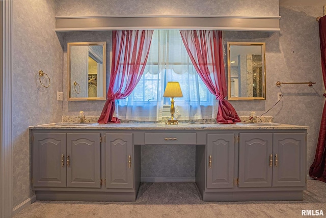 full bathroom with double vanity, wallpapered walls, and a sink