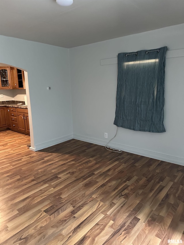 unfurnished room with wood finished floors and baseboards