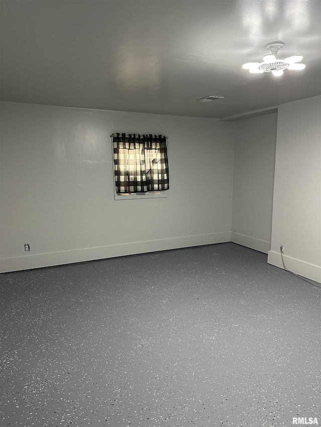 unfurnished room with visible vents, speckled floor, and baseboards