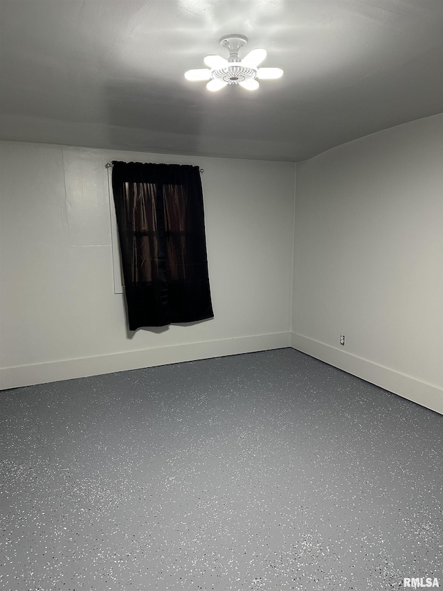 spare room with baseboards and speckled floor