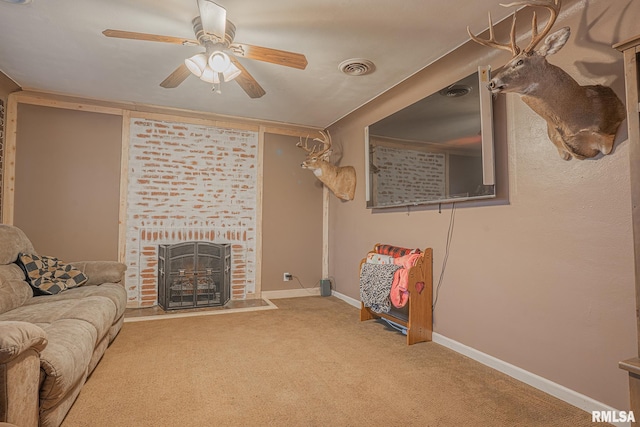 living area featuring ceiling fan, visible vents, baseboards, a brick fireplace, and carpet