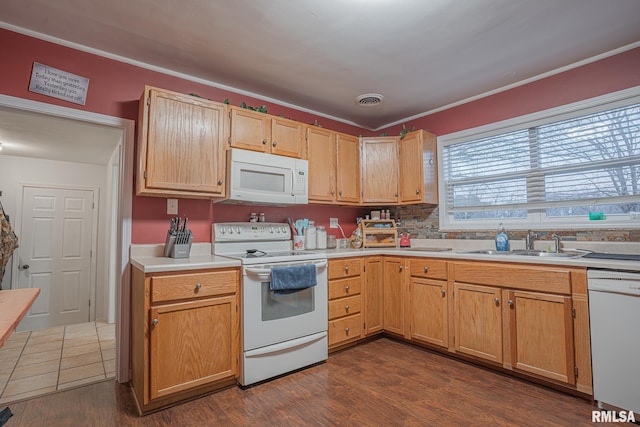 kitchen featuring dark wood-style flooring, light countertops, visible vents, a sink, and white appliances