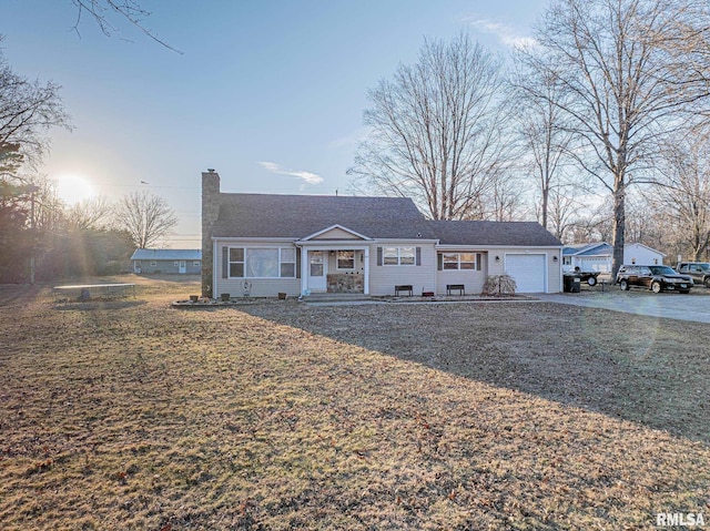 view of front facade featuring driveway, a chimney, and an attached garage