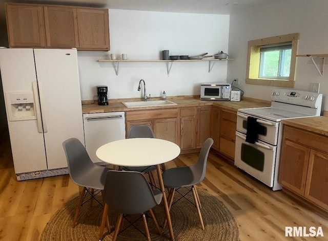 kitchen featuring open shelves, light wood-type flooring, stainless steel appliances, and a sink