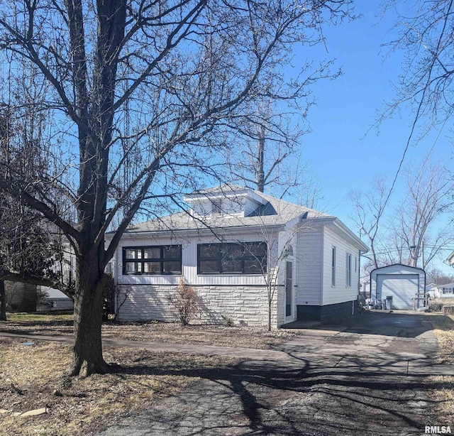 view of front of property with aphalt driveway, an outdoor structure, and a garage