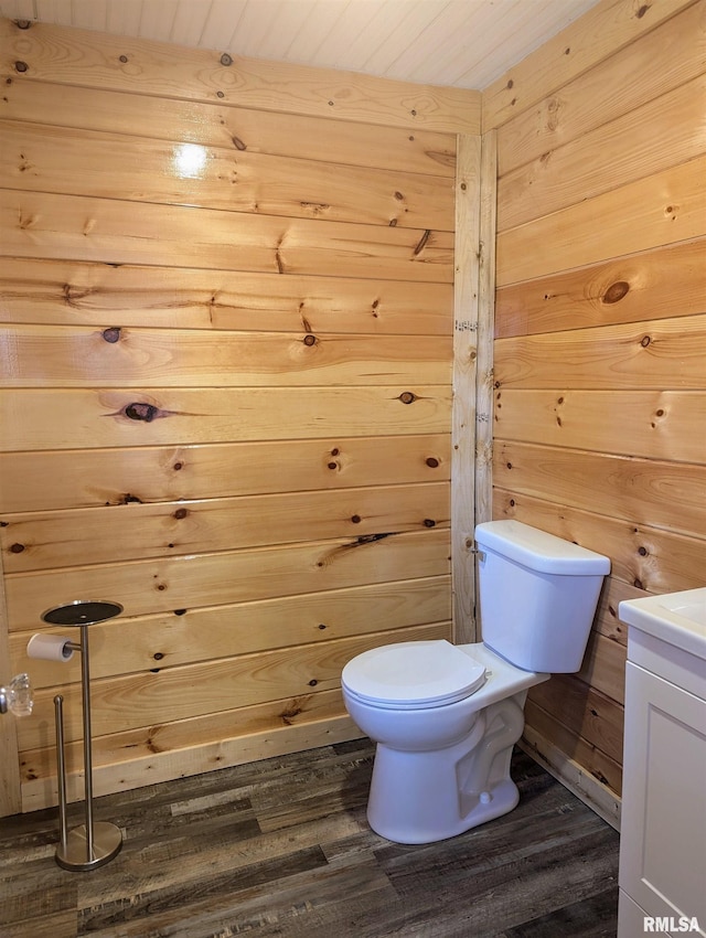 bathroom featuring wooden ceiling, toilet, wood walls, wood finished floors, and vanity