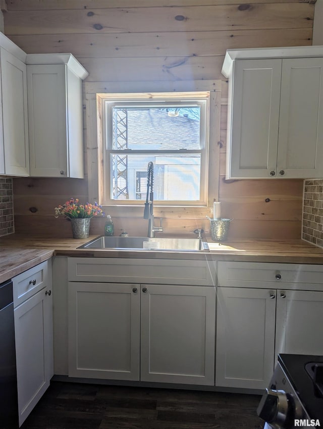 kitchen with tasteful backsplash, white cabinetry, light countertops, and a sink