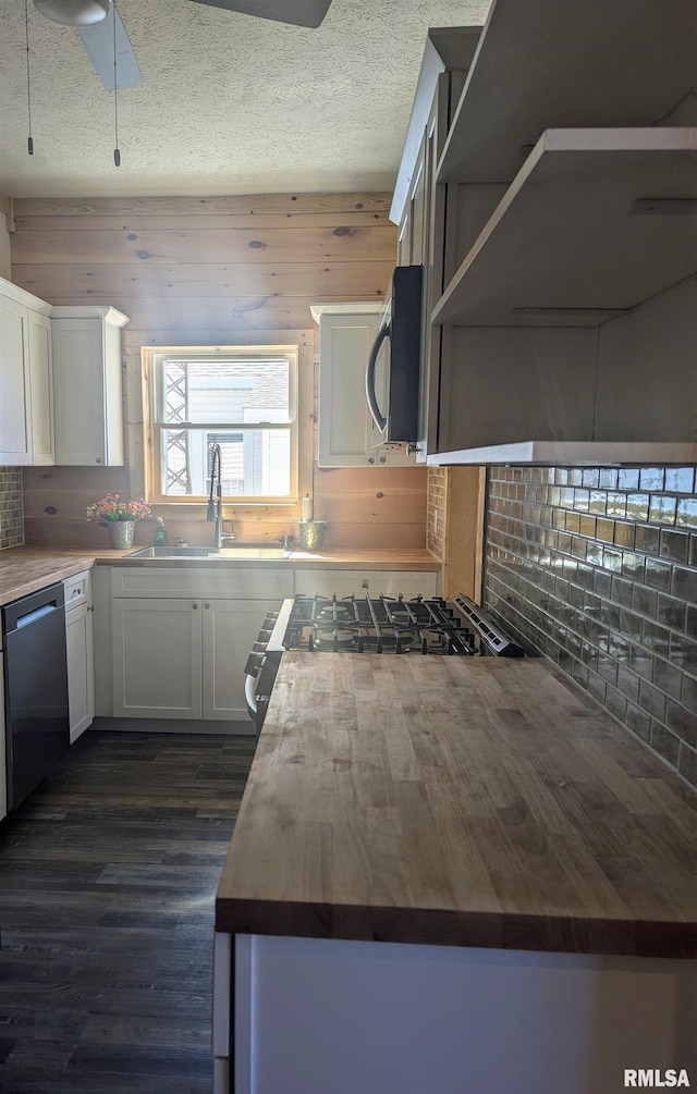 kitchen with appliances with stainless steel finishes, white cabinetry, a sink, and open shelves