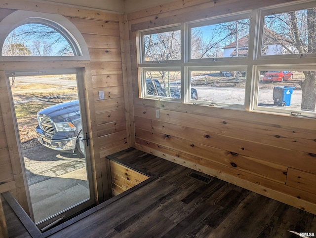 interior details featuring wood walls, visible vents, and wood finished floors