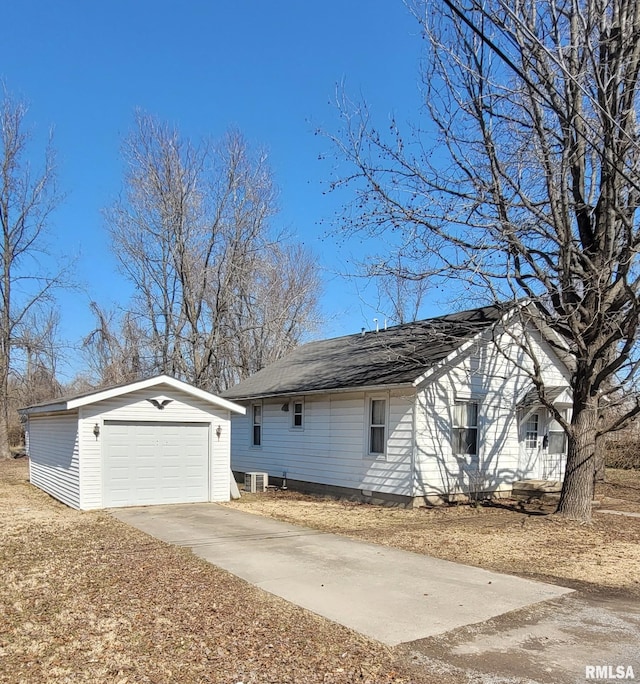 exterior space featuring a detached garage, central AC, concrete driveway, and an outdoor structure